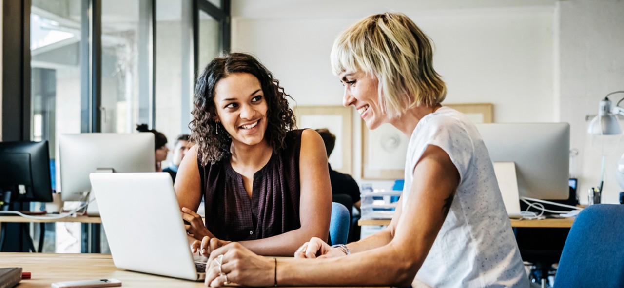 Two casual dressed start up businesswomen talking in a meeting with laptop